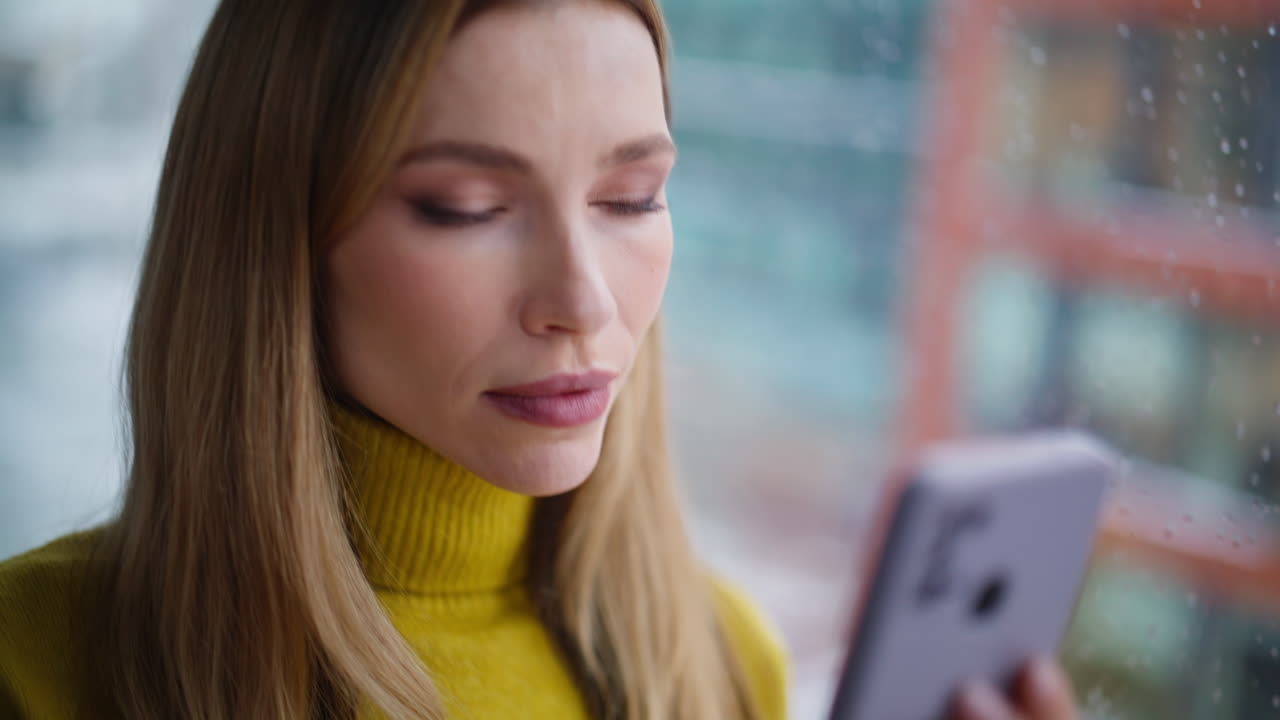 Business lady hands texting mobile phone standing by window city view closeup