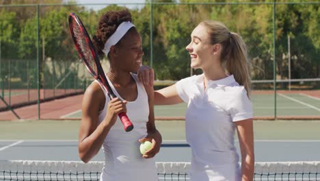 video of happy diverse female tennis players holding rackets and talking