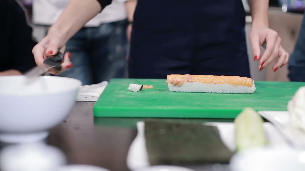 Hand Cuts The Roll. Knife in hand cuts the roll closeup