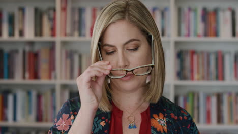 Retrato-Hermosa-Joven-Rubia-Se-Pone-Gafas-Mirando-Mujer-Caucásica-Inteligente-En-El-Fondo-De-La-Estantería-De-La-Biblioteca-Empresario-Independiente