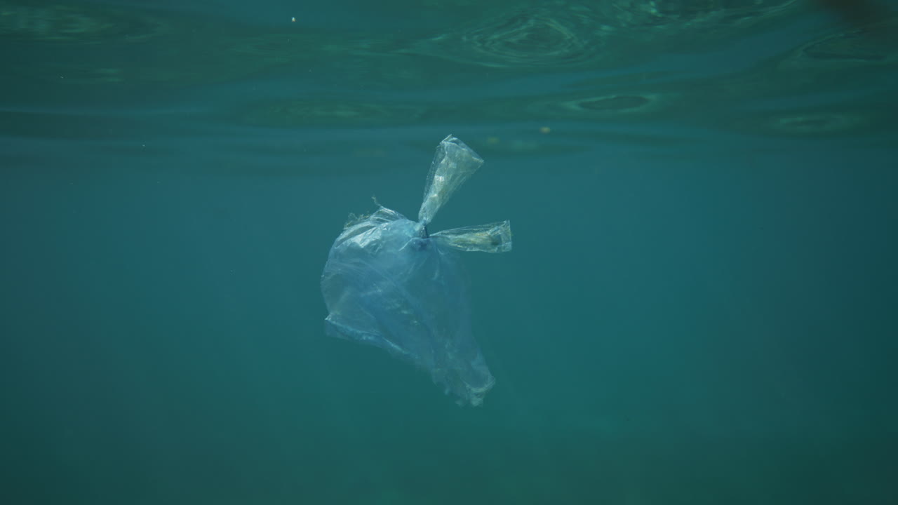 물 에서 빛이 반사되는 크리스탈 은 물에서 떠다니는 플라스틱 가방