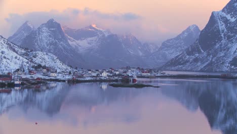 A-picture-perfect-shot-of-golden-sunset-clouds-behind-a-village-and-shoreline-amidst-fjords-north-of-the-Arctic-Circle-in-Lofoten-Islands-Norway