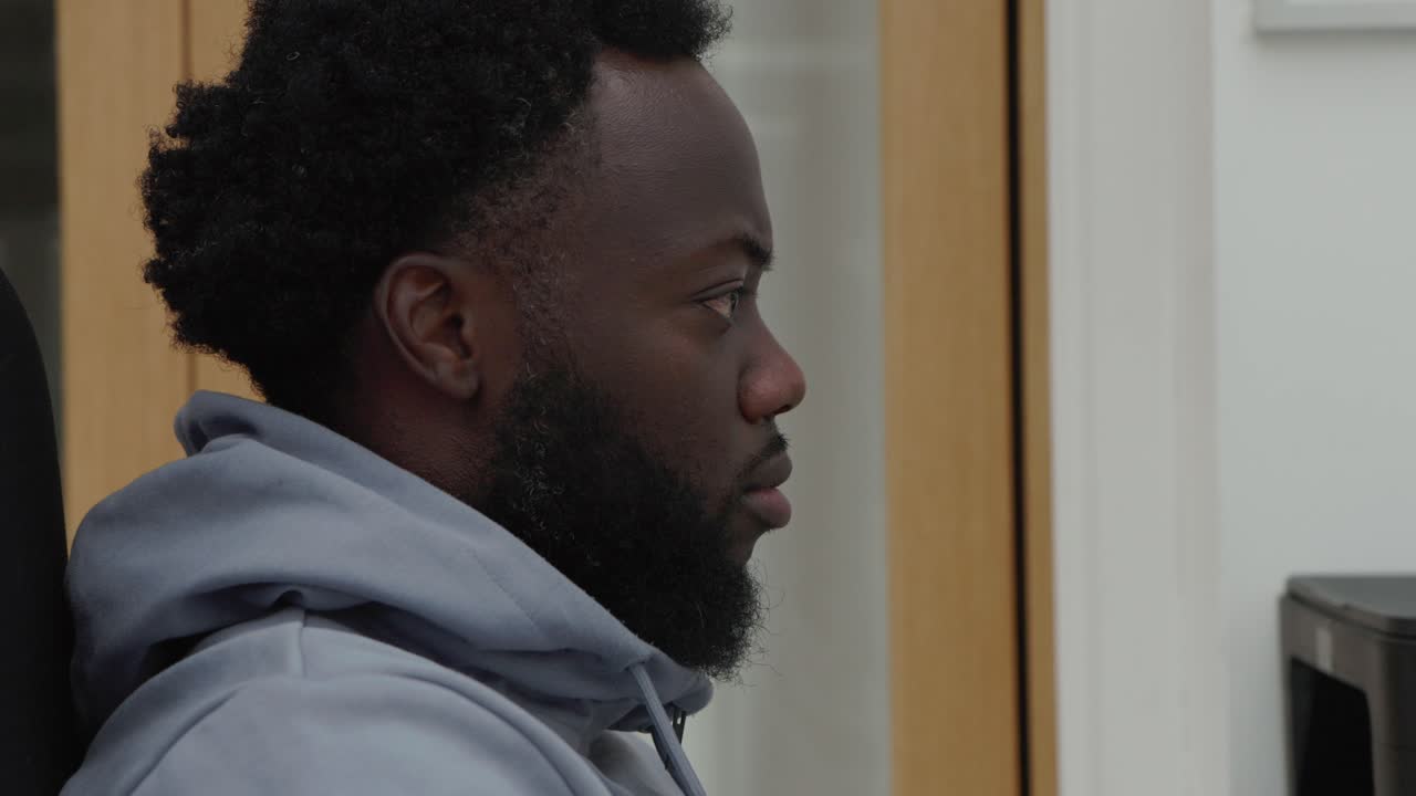 Black Male Working At Computer Desk In Home Office
