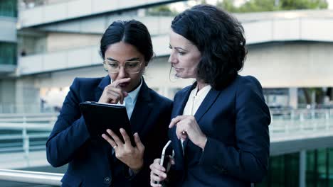 focused businesswomen with digital devices