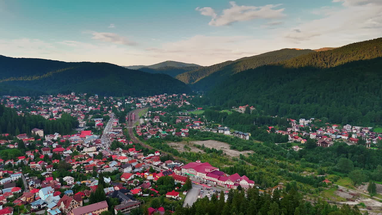Bellissima zona residenziale circondata da vegetazione lussureggiante e montagne. Vista aerea su Busteni, Romania