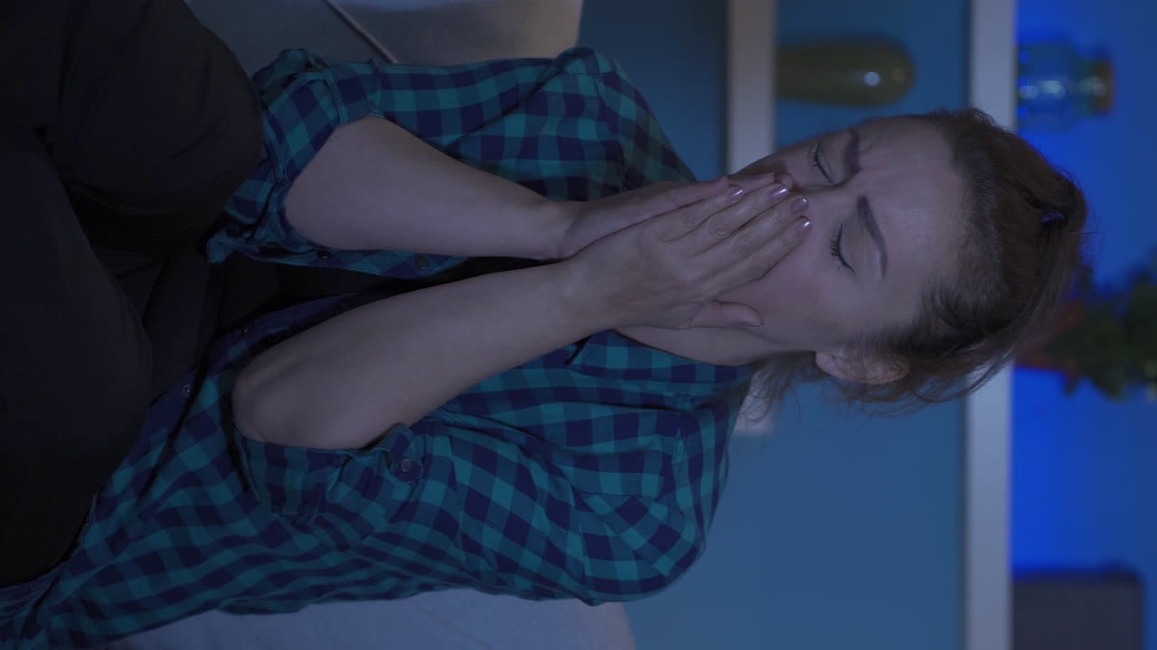video vertical de una mujer con problemas psicológicos en casa por la noche.
