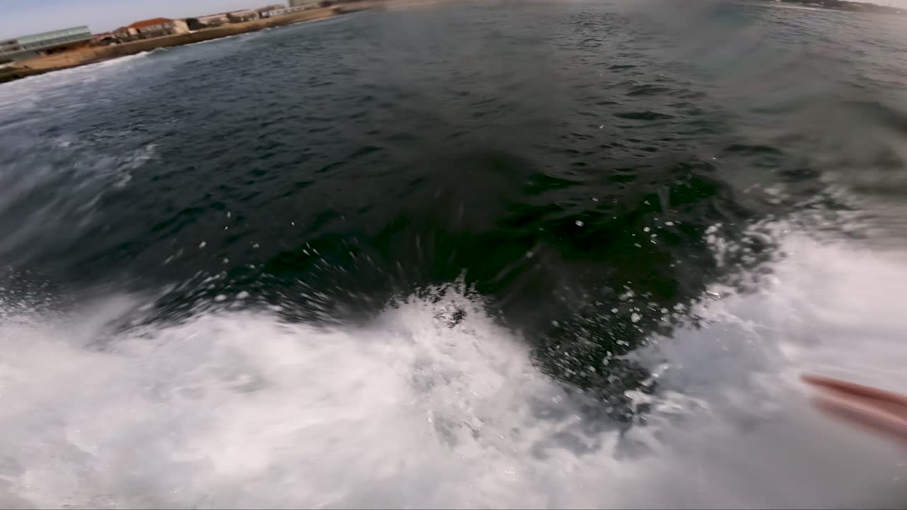 Surfista con tavola verde che cavalca le onde verdi del mare, POV