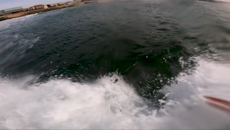 surfer with green board surfing green sea waves pov