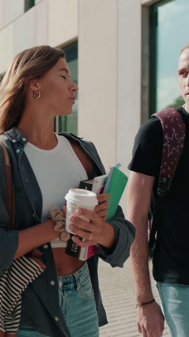 Side view of two female and male students walking around the city, going down