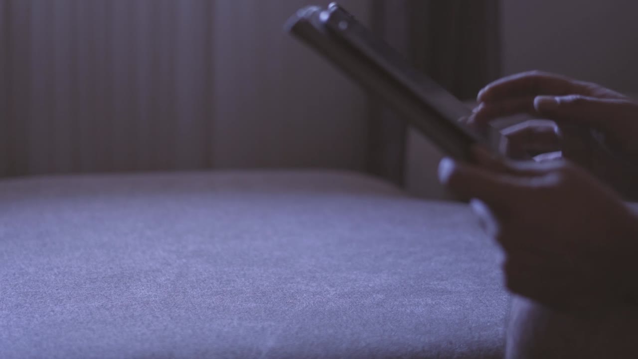 filmado en cámara lenta mostrando las manos del hombre navegando en las redes sociales o jugando con una tableta móvil por la noche