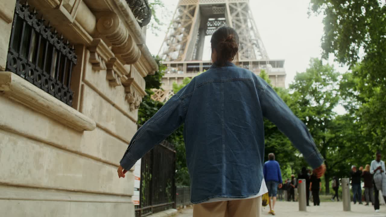 Donna che cammina verso la Torre Eiffel a Parigi