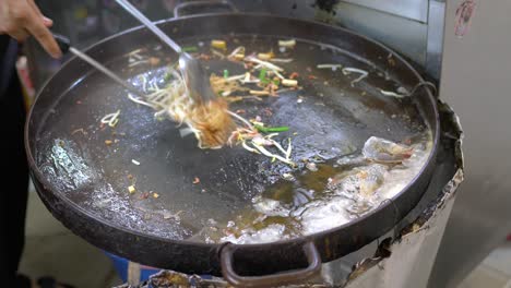 los vendedores ambulantes de comida hábilmente salteados deliciosos pad thai en yaowarat chinatown, bangkok