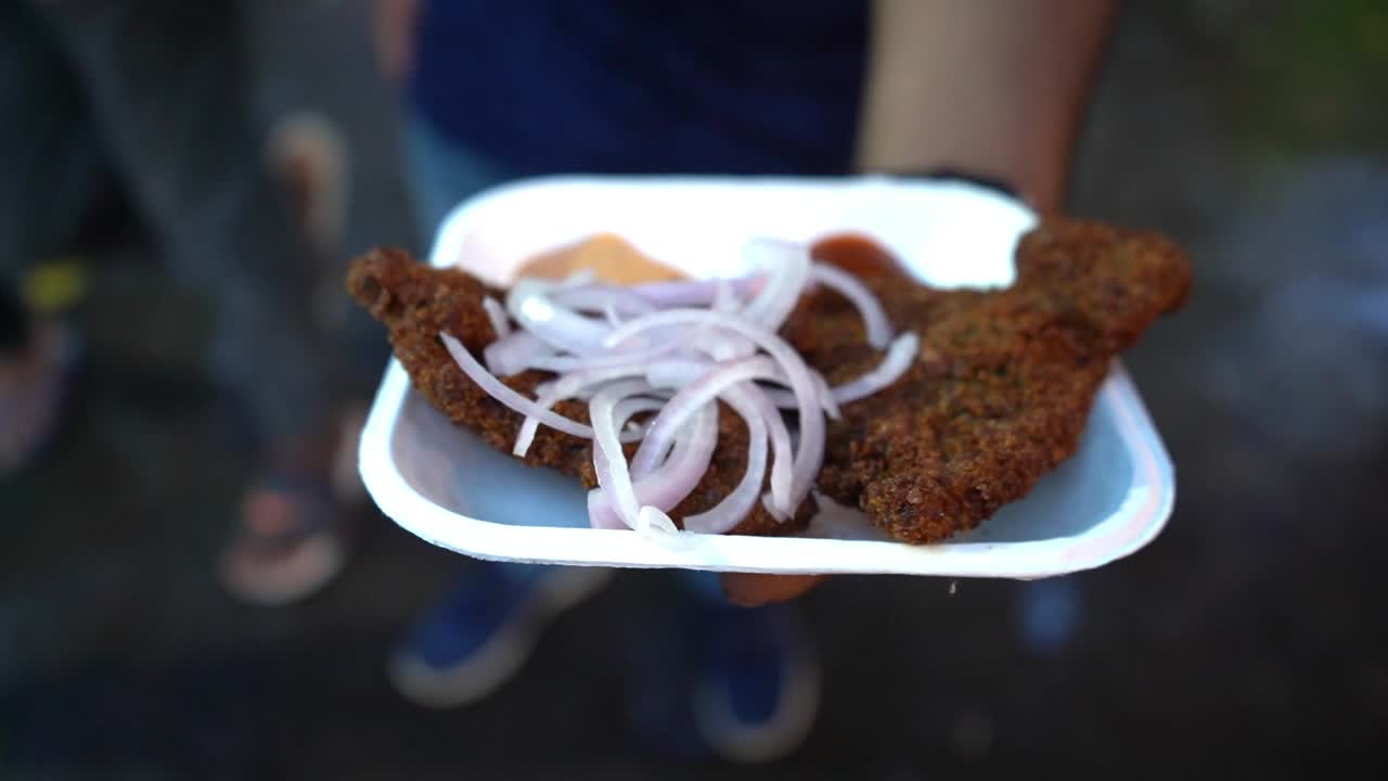 인기 있는 벵골 간식인 바삭한 생선 튀김을 들고 있는 얼굴 없는 남자의 비디오