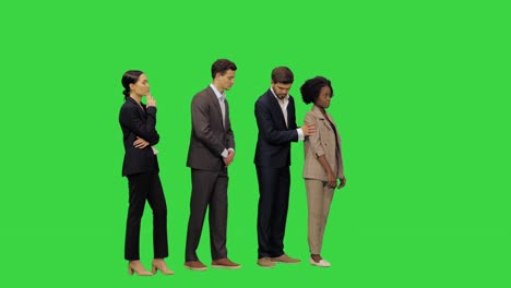 people standing in a line a cautious young man in business clothes offers his female colleague to switch positions, as he is taller and she cannot see a thing on a green screen, chroma key
