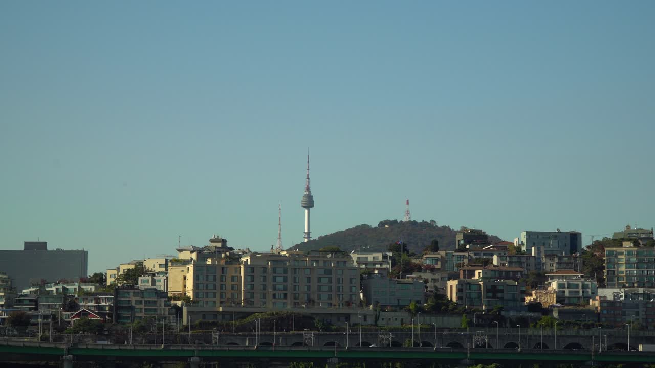 Cityscape of Namsun N Seoul Tower and Yongsan-gu District at bright day Seoul, South Korea. Traffic on Gangbyeon expressway with Namsan Mt. on clear blue cloudless sky background
