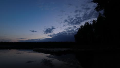 Lapso-De-Tiempo-Del-Tranquilo-Muelle-Del-Lago-Mientras-La-Tarde-Azul-Del-Bosque-Se-Convierte-En-Noche