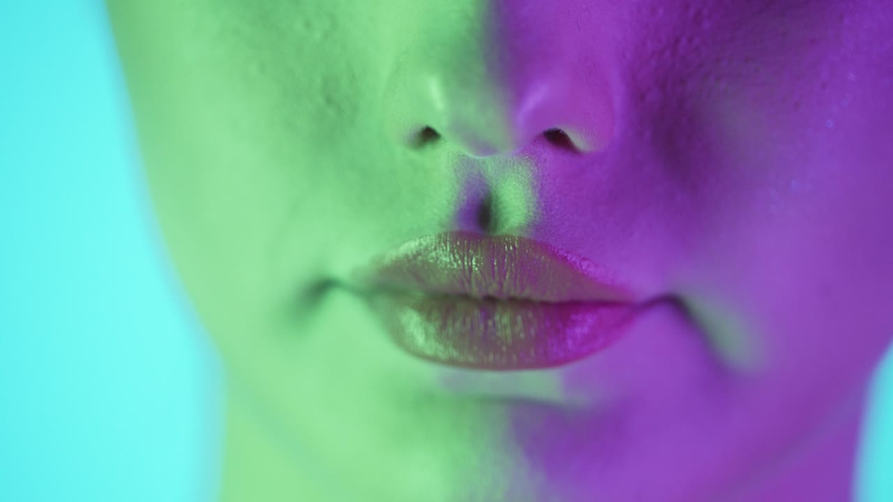 Extreme close up shot of a beautiful woman's lip as she presses her lips together to spread her newly applied lipstick after getting ready for club night evenly in slow motion