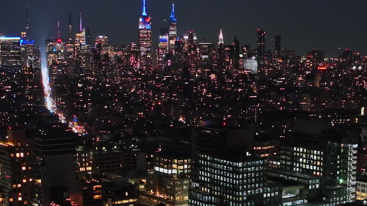 Vibrant New York City skyline illuminated at night from a drone view