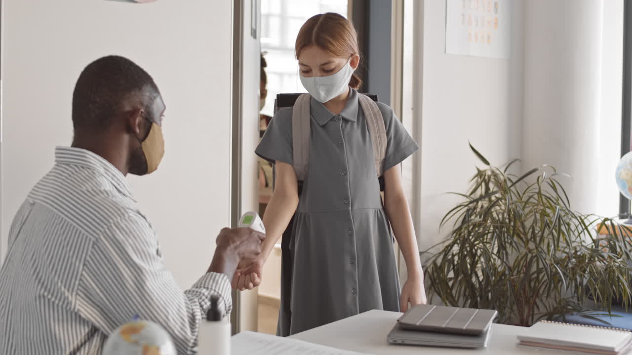 Multiethnic Schoolchildren Measuring Temperature in Classroom