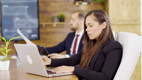 joven mujer de negocios escribiendo en la computadora en la sala de conferencias