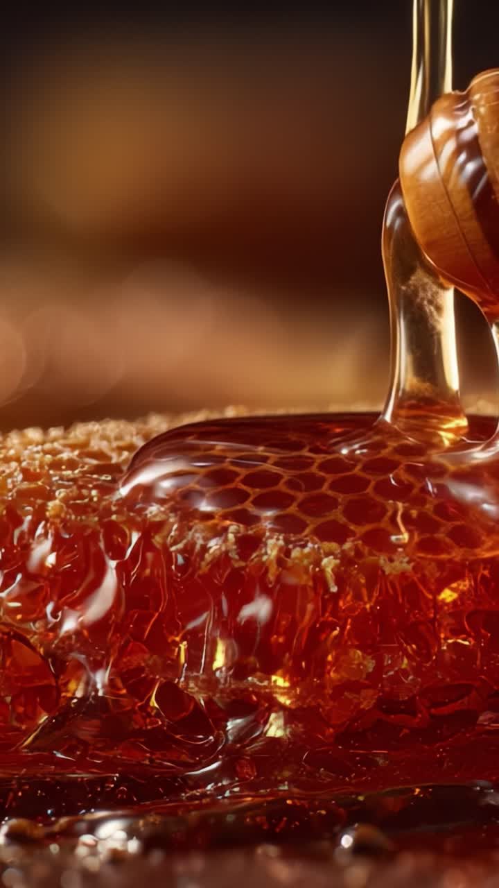 Primo piano di miele dorato che cola da un favo, mostrando la ricca consistenza e viscosità del miele liquido in un bellissimo ambiente con delicato effetto sfocato