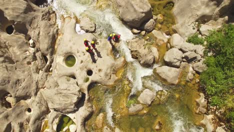 people walking over river on rocks