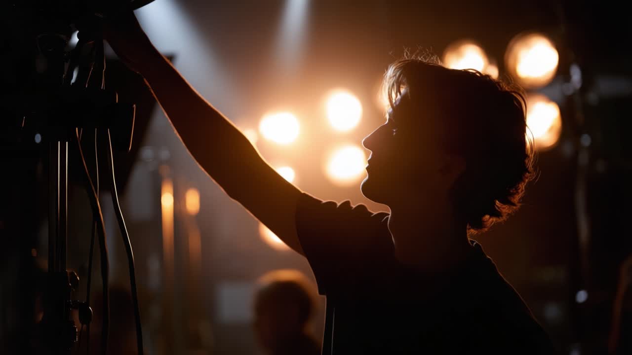 Illuminating Moments: A Staged Scene with a Focused Individual Preparing Lighting Equipment Under Vibrant Stage Lights