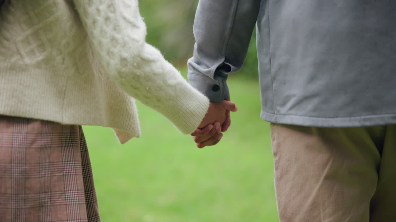 A couple holding hands in a park
