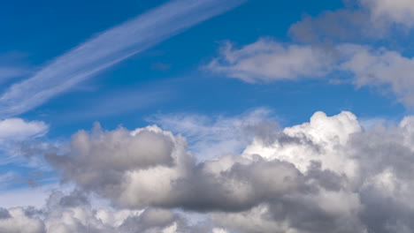 time lapse of dramatic cumulus clouds against clear blue sky, static, low angle