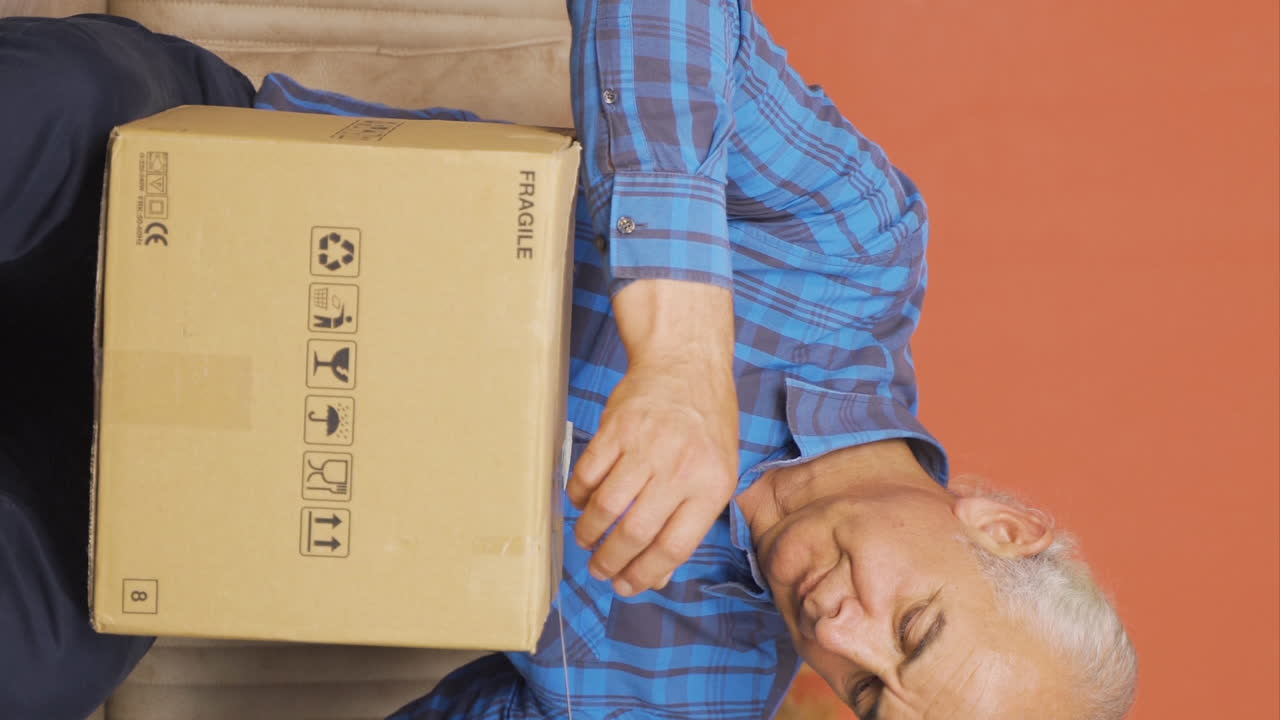 video vertical del anciano que abrió el paquete de carga.