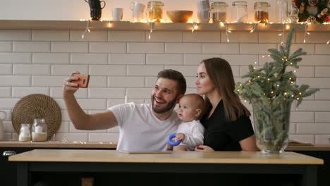 smiling parents with baby taking selfie family photo on bed at home