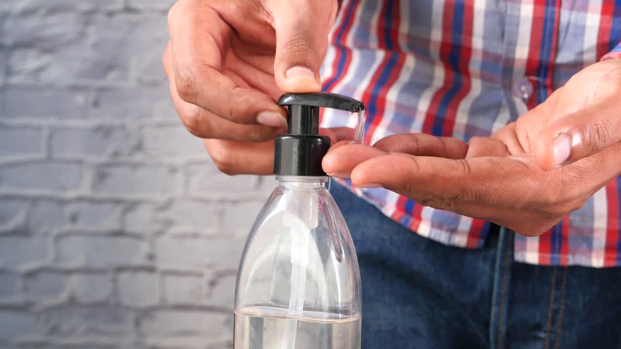 persona que aplica desinfectante para las manos