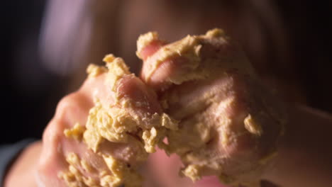 close up of child's messy hands rubbing butter all over hands while baking