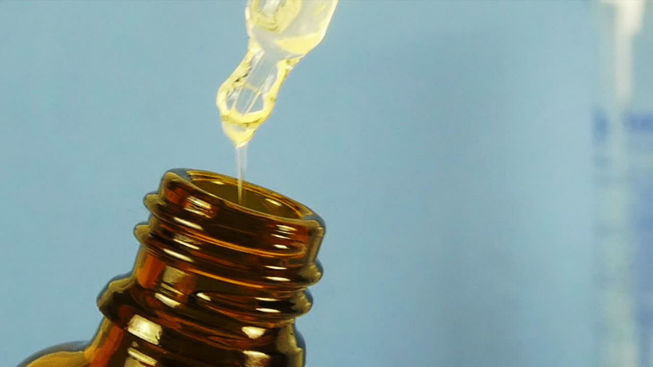 A captivating macro video showcasing a cosmetic serum dripping in slow motion, emphasizing its silky texture and transparency.