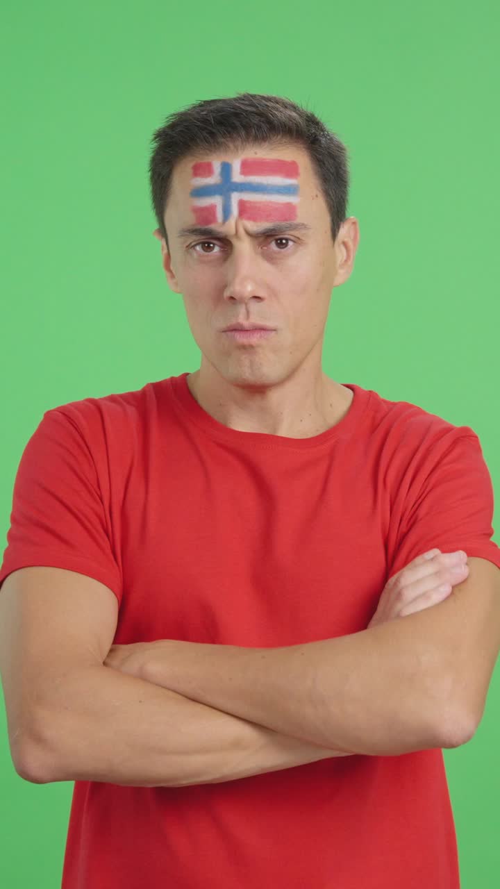 Dignified and serious man with norwegian flag painted on face