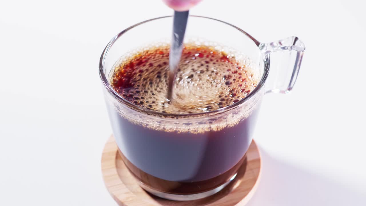 Teaspoon stirring coffee in a cup