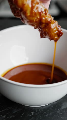 chicken wings dipping in sauce