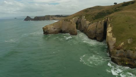 Orbiting-aerial-shot-of-cliffs-along-the-coastline-in-New-Zealand-during-the-day