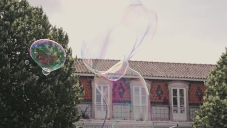 person blowing massive soap bubbles in city downtown