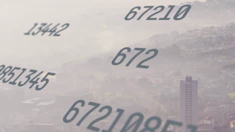 animation of changing numbers over aerial view of fog covered modern city against sky