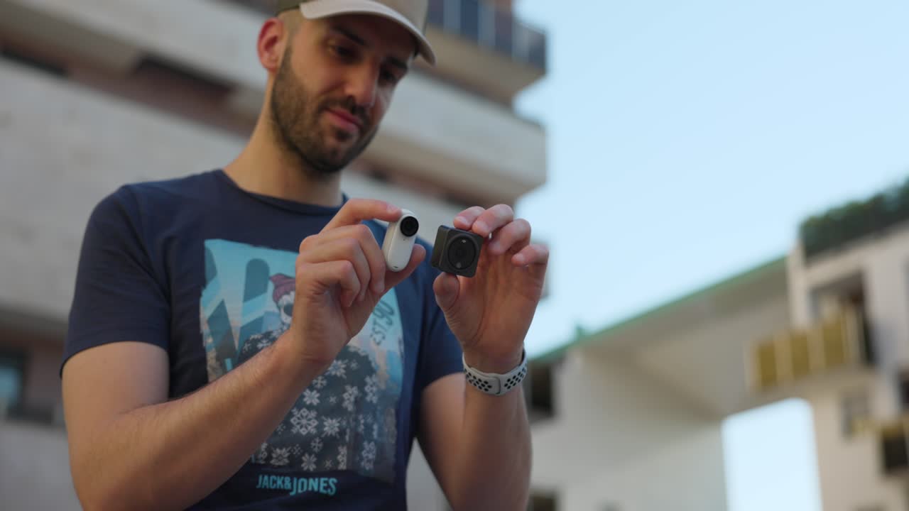 influencer con dji action 2 e insta360 go 3 en ambas manos