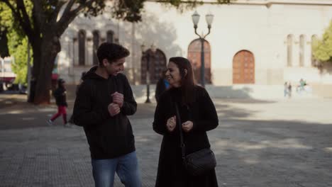 Two people walking and talking in a public square