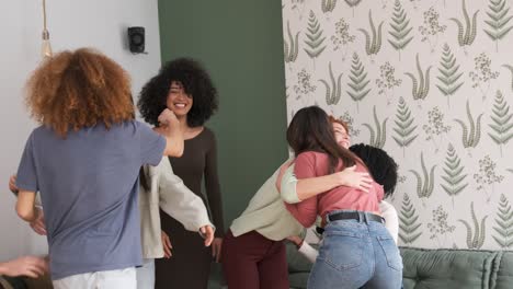 multiethnic friends embracing each other at home
