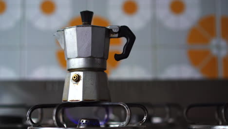 Close-up-of-adult-man-hand-turning-on-gas-stove-with-piezoelectric-gas-lighter-for-making-a-coffee-with-traditional-Italian-neapolitan-moka-machine-4k