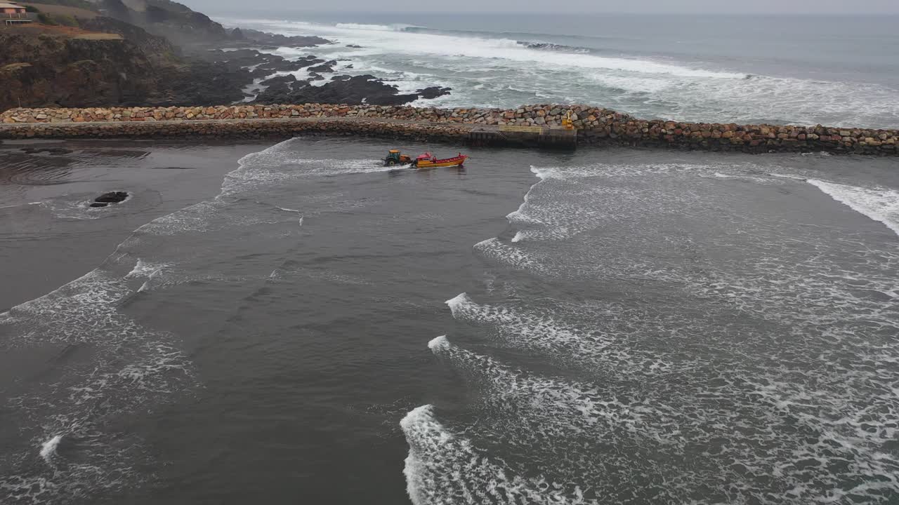 barco de pesca yendo a pescar en un día de oleadas en la costa de chile bucalemu grabación de un dron