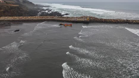 fishing boat going fishing on a day of swells on the coast of chile bucalemu recording of a drone