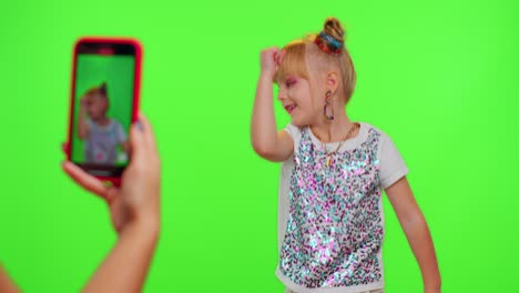 happy funky blogger child kid girl, recording funny dancing video on smartphone for social network
