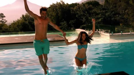 Happy-couple-jumping-in-swimming-pool-together