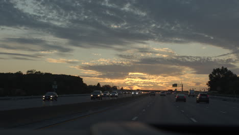 Punto-De-Vista-Del-Conductor-Conduciendo-Por-Una-Carretera-Al-Atardecer