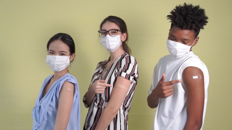 Diverse group of people showing COVID-19 vaccine bandage merrily
